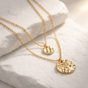 پلاکهای سکهای گردنبند دو لایه طلایی روی سنگ تزیینی