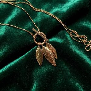 گردنبند رومانتویی طلایی آی ام مدل سه برگ روی پارچه