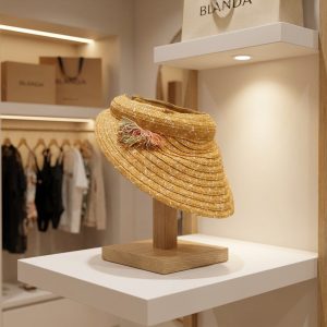 کلاه آفتابگیر حصیری زنانه کرم آی ام روی استند چوبی فروشگاهی